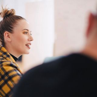 Donna che discute sorridendo in ufficio, confronto su scelta gestore energia nel Mercato Libero, ambiente lavorativo luminoso