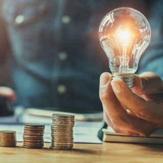 Icona rossa di una mano che riceve una moneta euro, simbolo di risparmio economico e gestione delle spese domestiche