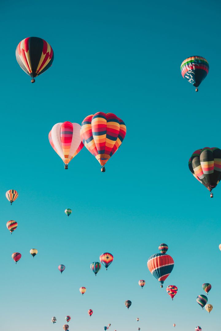 Mongolfiere colorate che si alzano in cielo limpido, concetto di aumento prezzi bollette e opportunità di risparmio