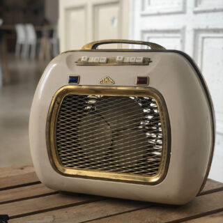 Stufetta elettrica vintage beige e oro su tavolo in legno, esempio di elettrodomestico ad alto consumo energetico
