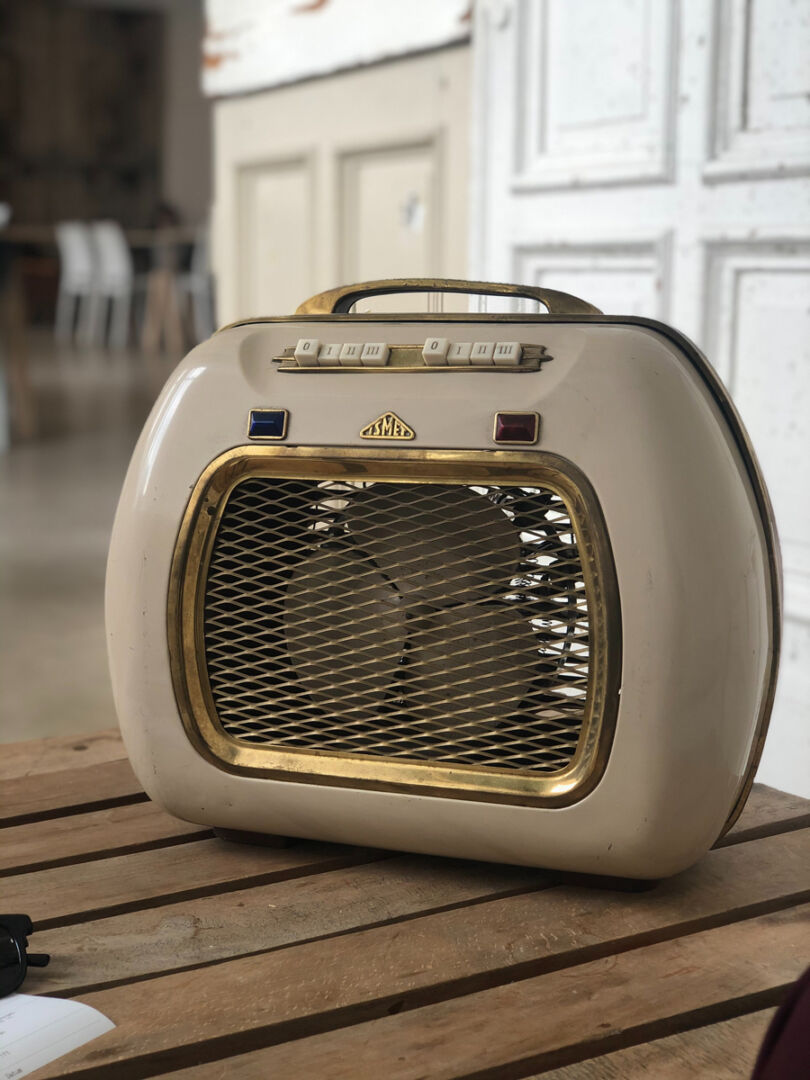 Stufetta elettrica vintage beige e oro su tavolo in legno, esempio di elettrodomestico ad alto consumo energetico